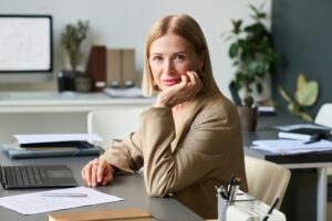 Femme consultante externe en entreprise assise à son bureau, regard professionnel