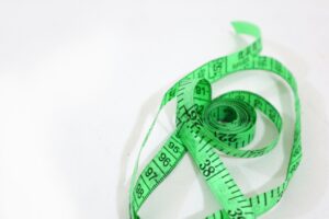 Ruban de mesure vert sur fond blanc, illustrant l’évaluation de l’impact d’une démarche QVCT