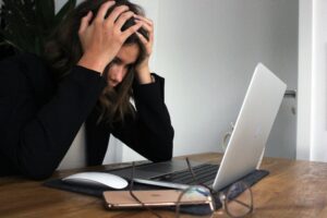 Femme au travail en situation de tension, premiers signes de risques psychosociaux en entreprise