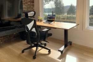 Poste de travail ergonomique devant une fenêtre, illustrant l’intégration de l’ergonomie dans le DUERP