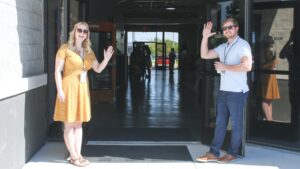 Deux personnes accueillant à l’entrée d’un bâtiment, illustrant la prévention des RPS dès l’intégration des salariés
