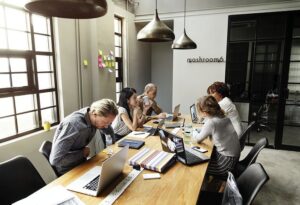Équipe en réunion de travail autour d’une table, illustrant les dynamiques collectives dans la prévention des RPS