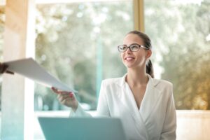 Encadrante souriante recevant un document, illustrant l’implication des managers dans une démarche QVCT