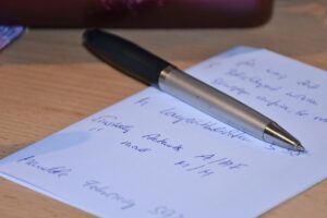 stylo sur une feuille manuscrite listant des actions à prévoir pour la formation CSE