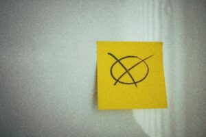 Symbole de vote dessiné sur un post-it jaune, illustrant une prise de décision pour choisir son organisme agréé de formation CSE.